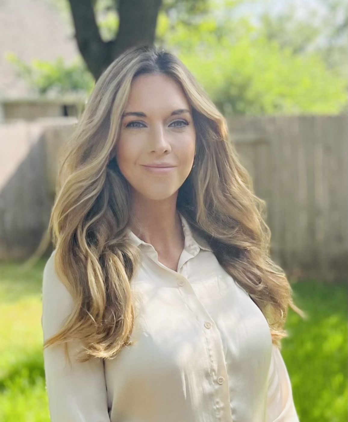 Tara Wilkins, LCSW, licensed therapist and life coach, smiling outdoors in a garden