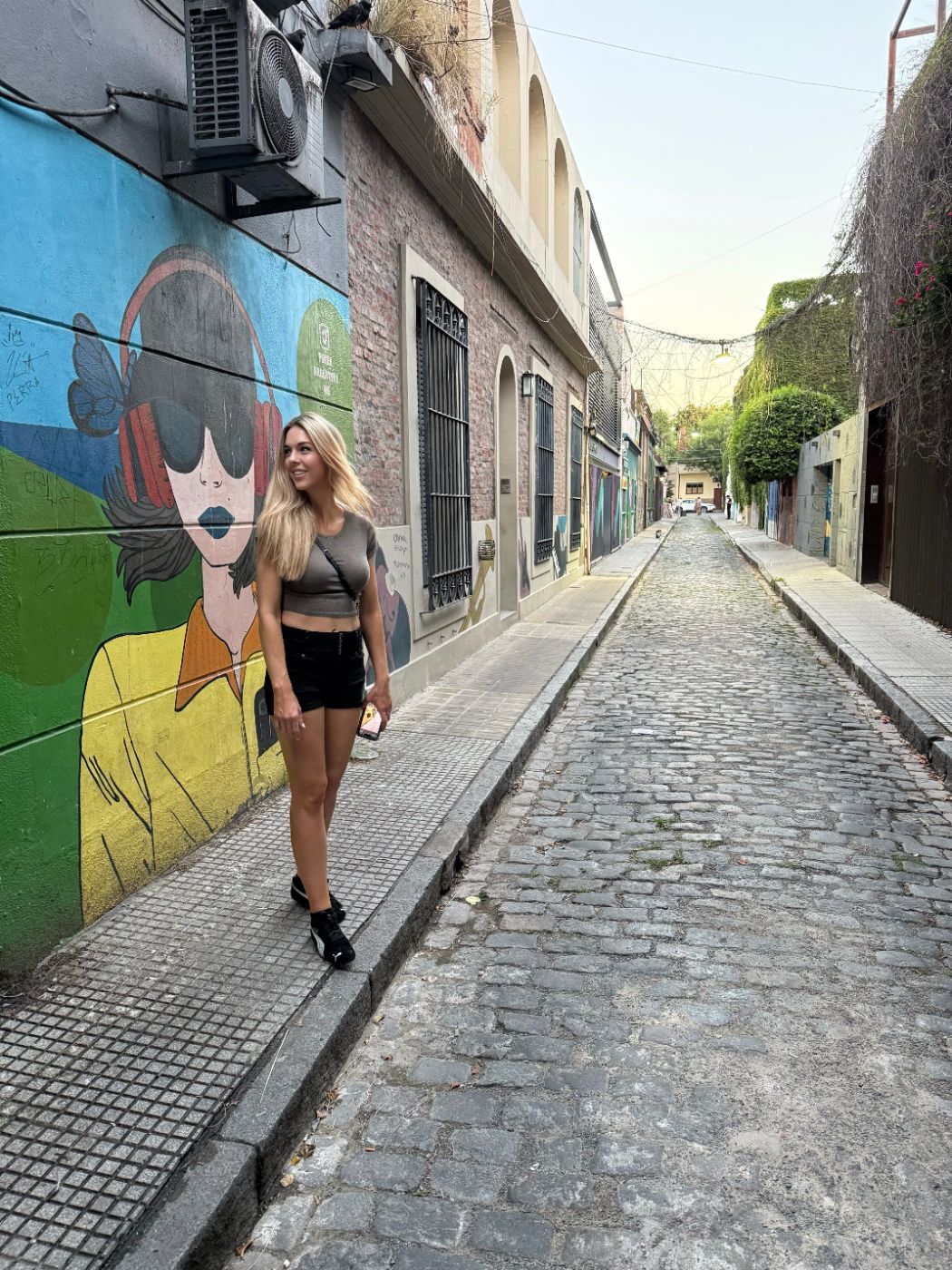 Tara Wilkins walking down a colorful mural-lined street